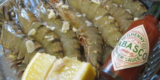 тигровые креветки с табаско, лимоном и чесноком на листовой подушке с теплой питой