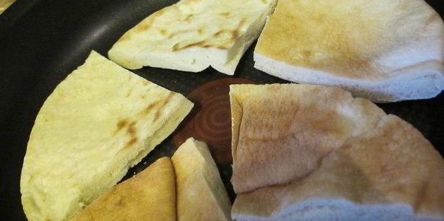 тигровые креветки с табаско, лимоном и чесноком на листовой подушке с теплой питой