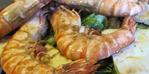 тигровые креветки с табаско, лимоном и чесноком на листовой подушке с теплой питой