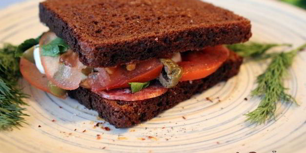 сендвич из ржаного хлеба с салями и помидором