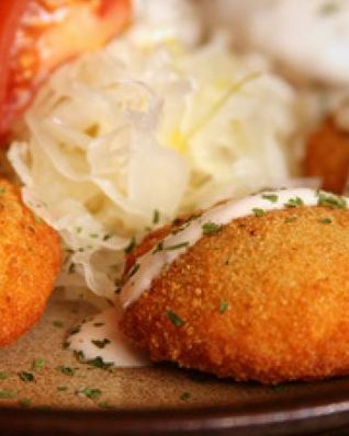 Картофельные пирожки под соусом с начинкой и овощами